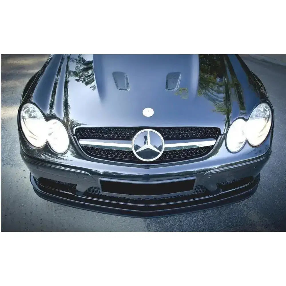 Spoiler på Mercedes CLK W209 front, svart grill med emblem og doble frontlykter, refleksjoner på panseret.