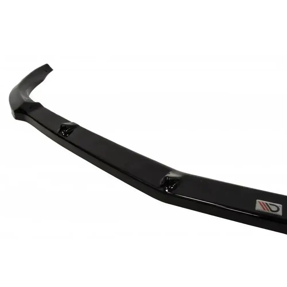Front lip til Mercedes CLS C219 standard bumper i sort blank plast, vist fra skrå vinkel med logo.
