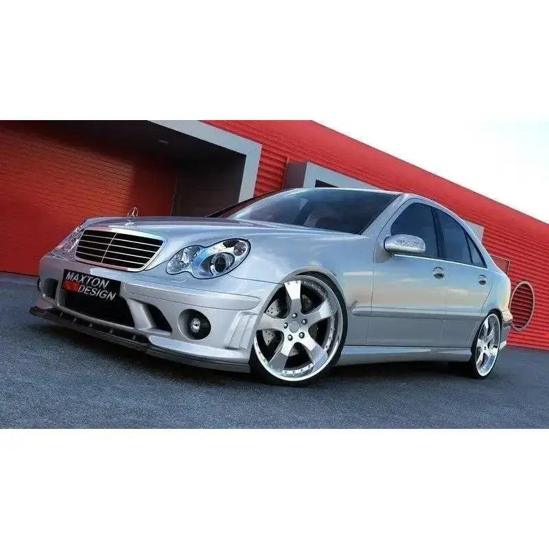Frontspoiler Mercedes C203 AMG204 F1 Bumper på sølvfarget sedan med store felger, lav vinkel, rød bygning bak.