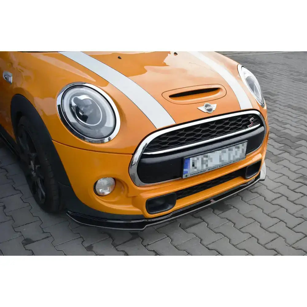 Spoiler på Mini Cooper S Mk3 Preface F56, svart under front med oransje karosseri og hvite striper.