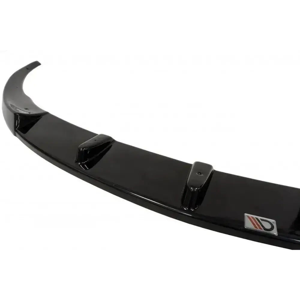 Frontspoiler Opel Astra J OPC i sort blank plast med tre finner og logo, sett fra skrå vinkel.