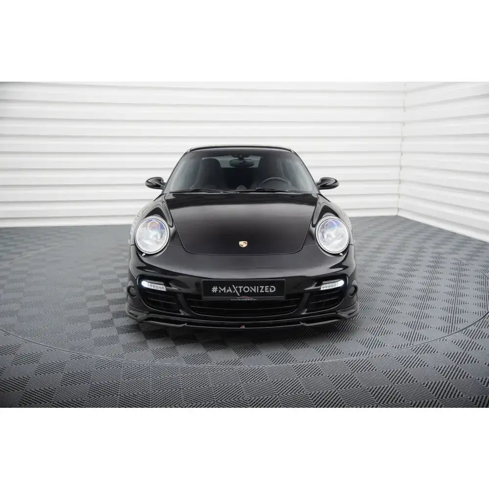 Spoiler på Porsche 911 Turbo 997 sett forfra, svart finish og runde frontlykter i lyst rom.