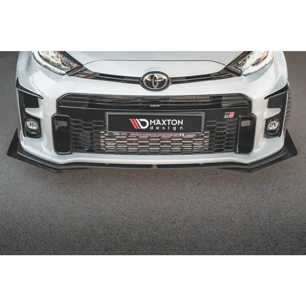 Frontspoiler Racing Durability med flaps montert på hvit Toyota GR Yaris MK4 sett forfra.