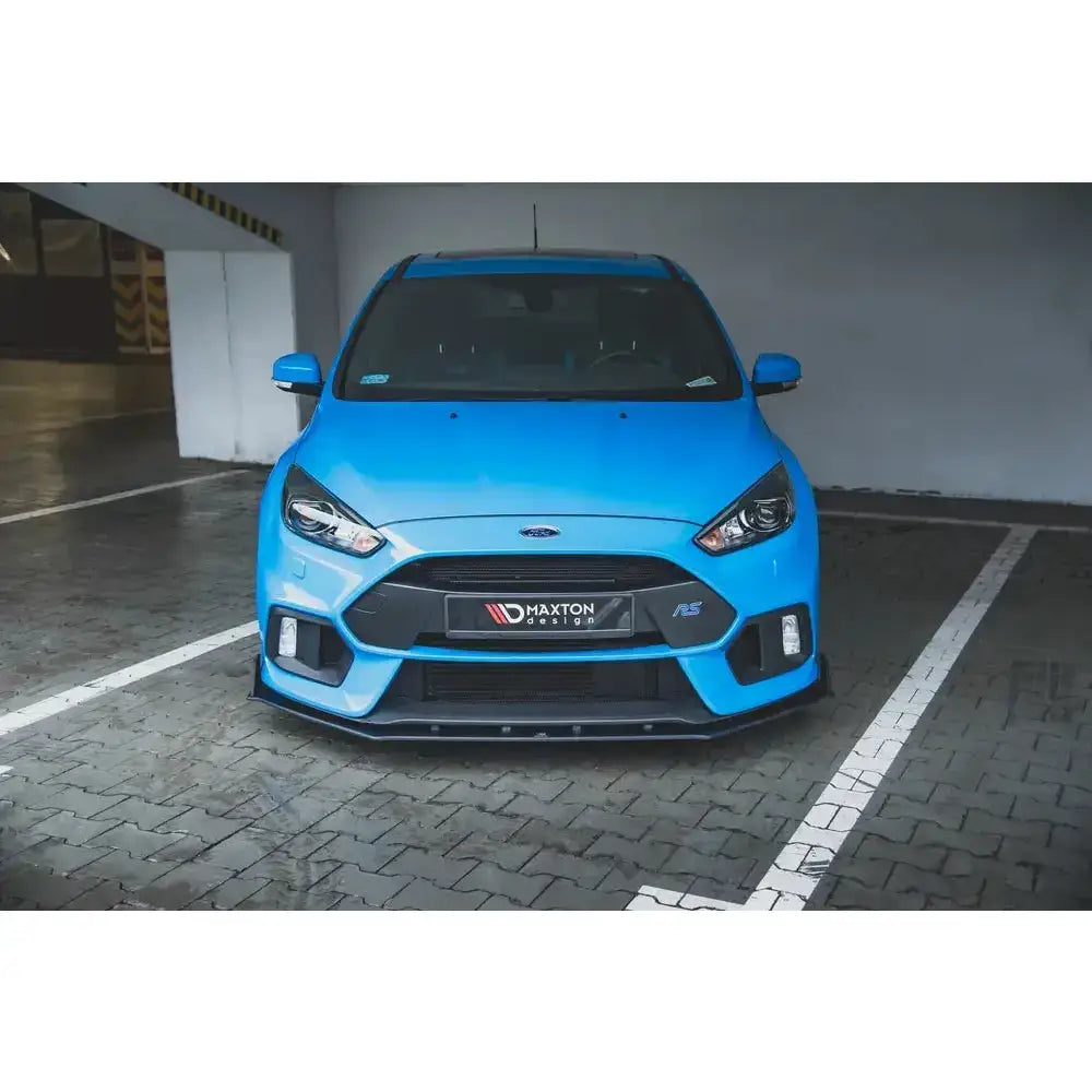Spoiler til Ford Focus RS Mk3 Racing Durability V.2 montert på blå sportsbil, sett forfra i parkeringshus.