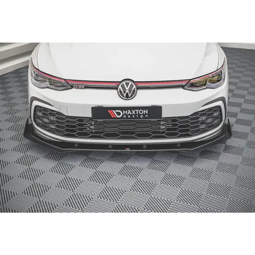Spoiler på Volkswagen Golf 8 GTI med svart racingfrontspoiler og røde detaljer sett rett forfra.