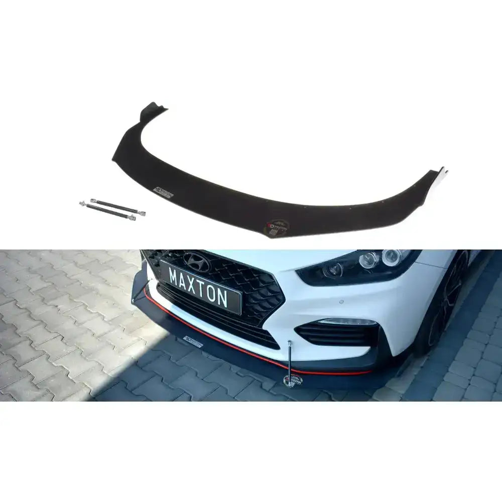 Frontspoiler Hyundai I30 Mk3 N Racing i sort plast med rød stripe, montert på hvit bil med metallstøtter.
