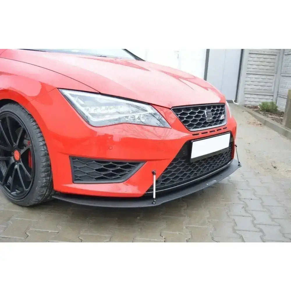 Front splitter på rød Seat Leon III Cupra med sort plastspoiler og metallstag, sett skrått forfra.