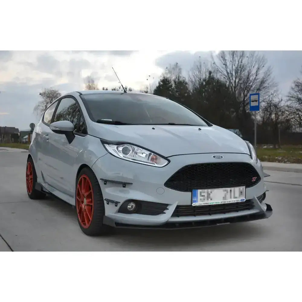 Spoiler på Ford Fiesta Mk7 St Facelift V.7 Racing med sorte detaljer og røde felger, sett skrått forfra.