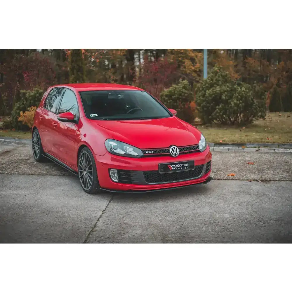 Frontspoiler Racing V.3 på rød Volkswagen Golf GTI MK6 med mørke felger, parkert foran høstbusker.