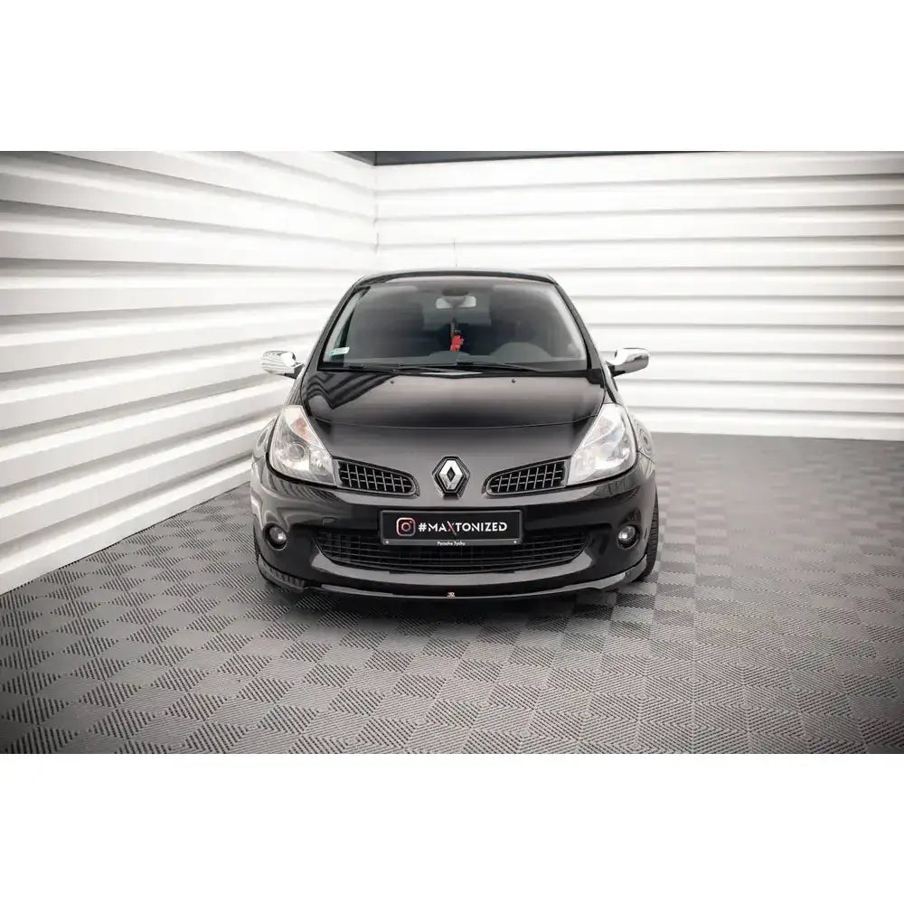 Frontspoiler på Renault Clio III Rs sett forfra, med kromdetaljer på speilene, innendørs.