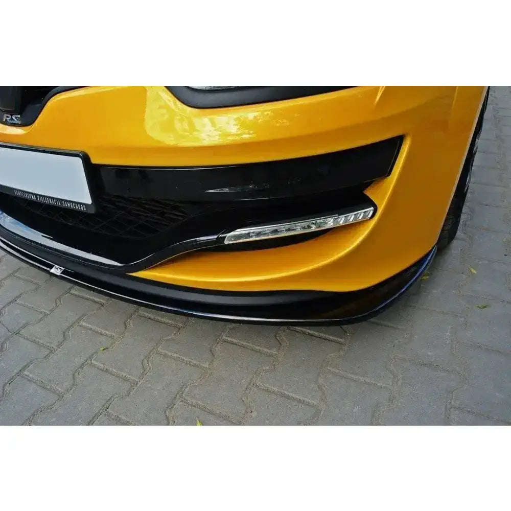 Front lip på Renault Megane 3 Rs V.2, gul bil med svart spoiler, delvis synlig grill og tåkelys.