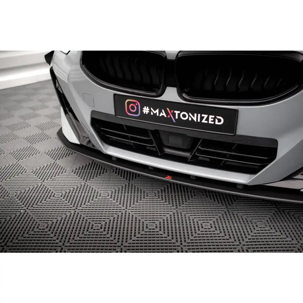 Front splitter på BMW 2 Coupe M-Pack G42, grå og svart frontfanger med rød detalj, sett fra lav vinkel.
