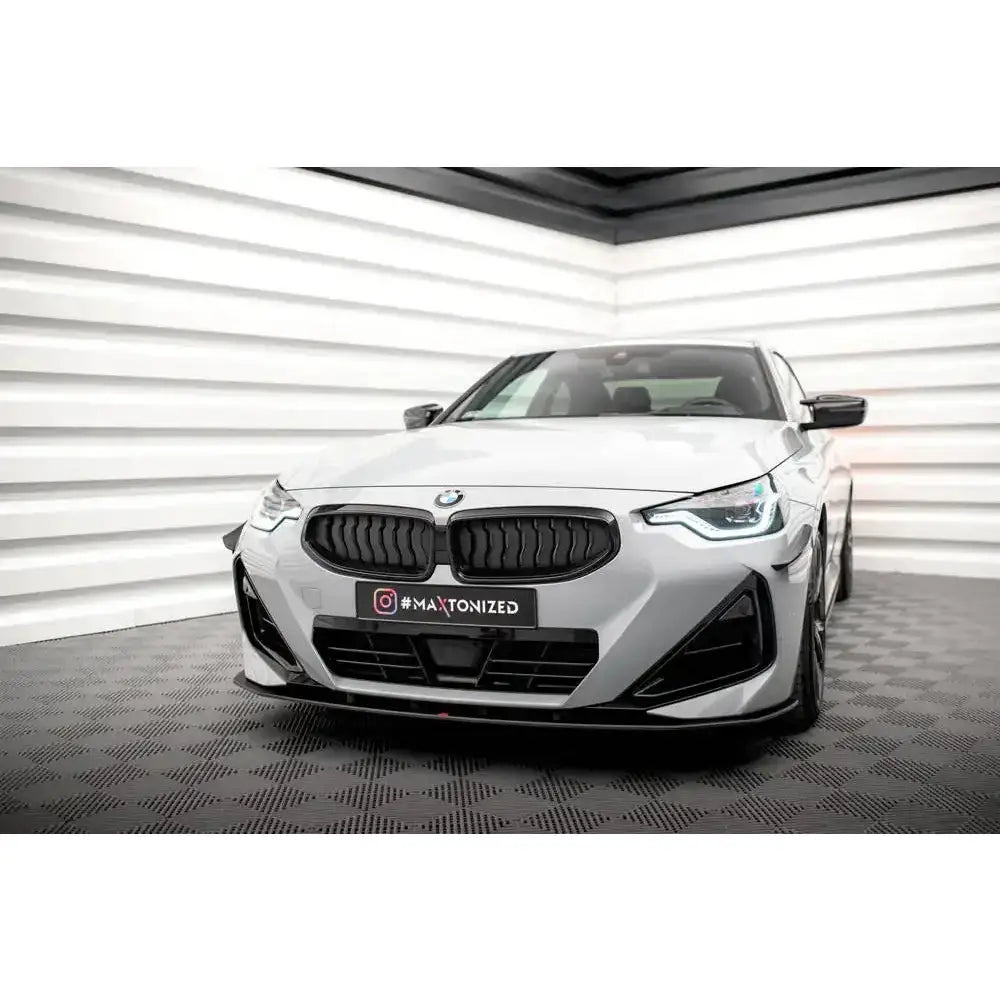 Front splitter på BMW 2 Serie Coupe M-Pack G42 med sorte detaljer, fotografert forfra i lyst rom.
