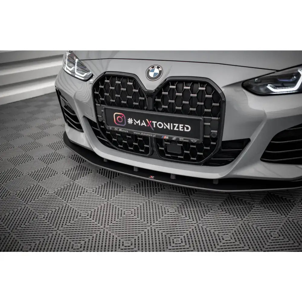 Front splitter til BMW 4 Gran Coupe G26 Street Pro, sort plast under stor grill, nærbilde på mønstret gulv.
