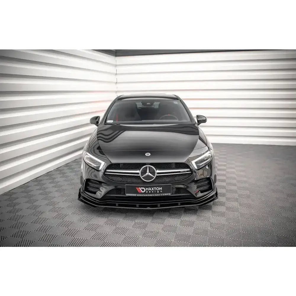 Frontspoiler på Mercedes A35 AMG med blank finish, markerte frontlykter og stående på grått gulv.