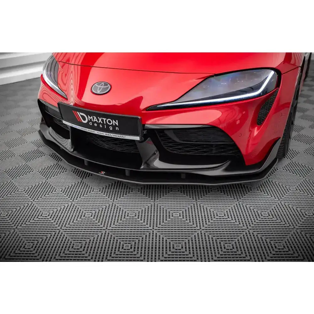 Frontleppe til Toyota Supra Mk5 Street Pro, sort blank plast, nærbilde fra lav vinkel mot rød bilfront.