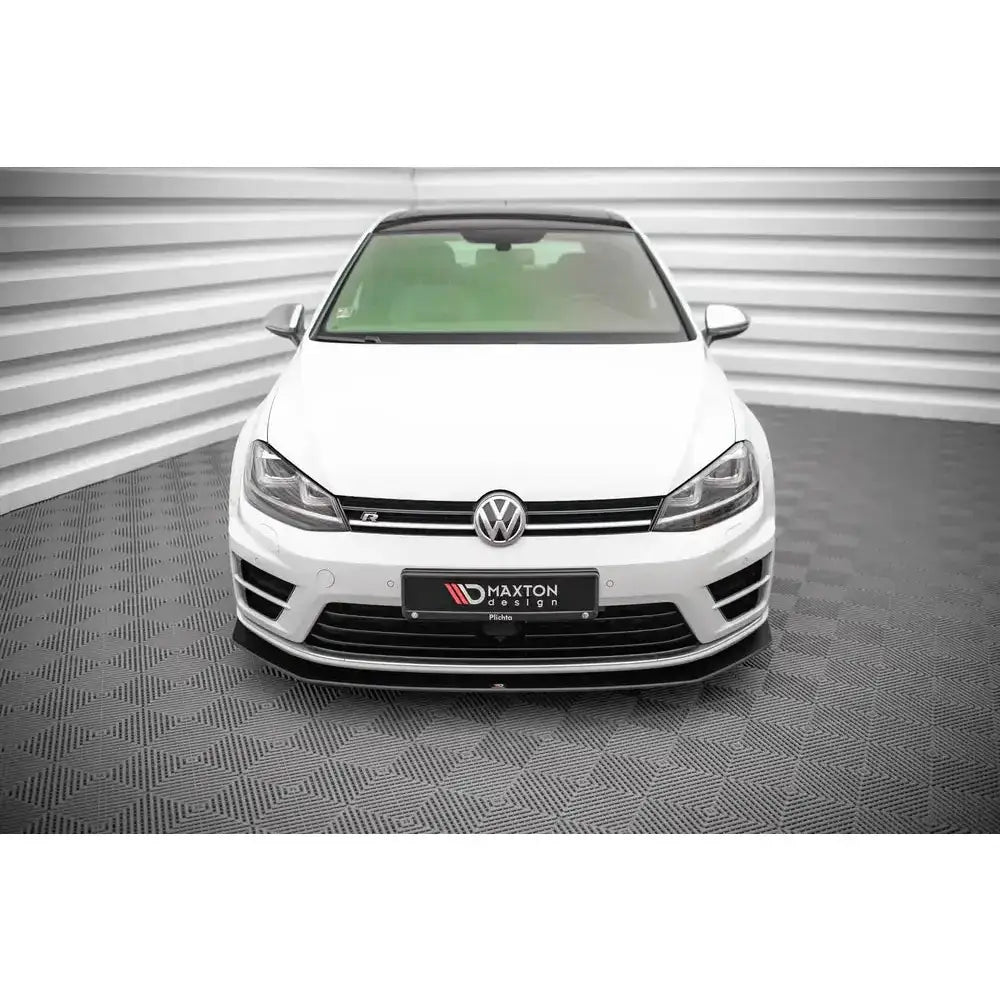 Frontspoiler Street Pro V.2 montert på hvit Volkswagen Golf R Mk7, sett forfra i lyst showroom.