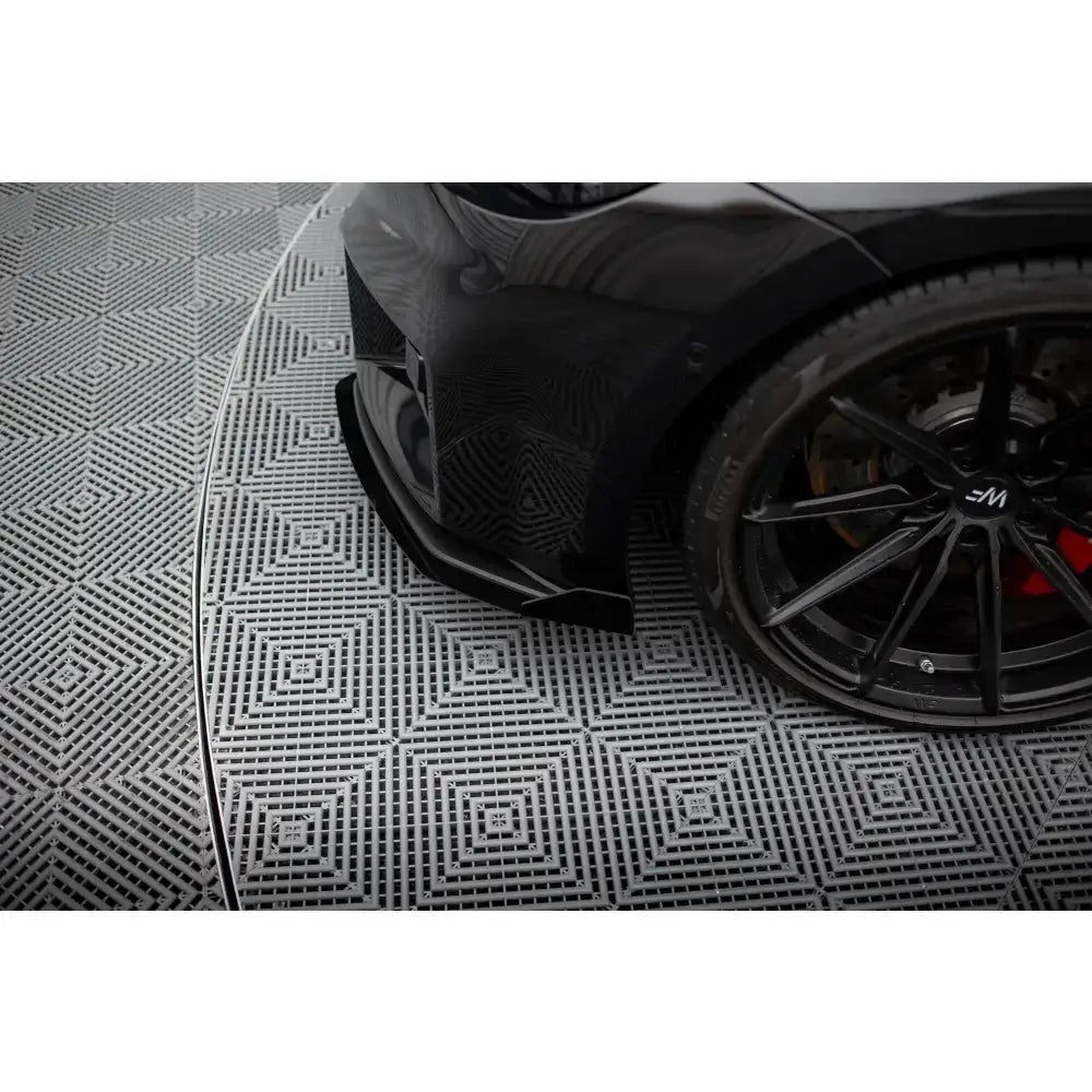 Front lip på BMW M2 G87 Street Pro V.1 med flaps, nærbilde av hjul og støtfanger på svart bil.