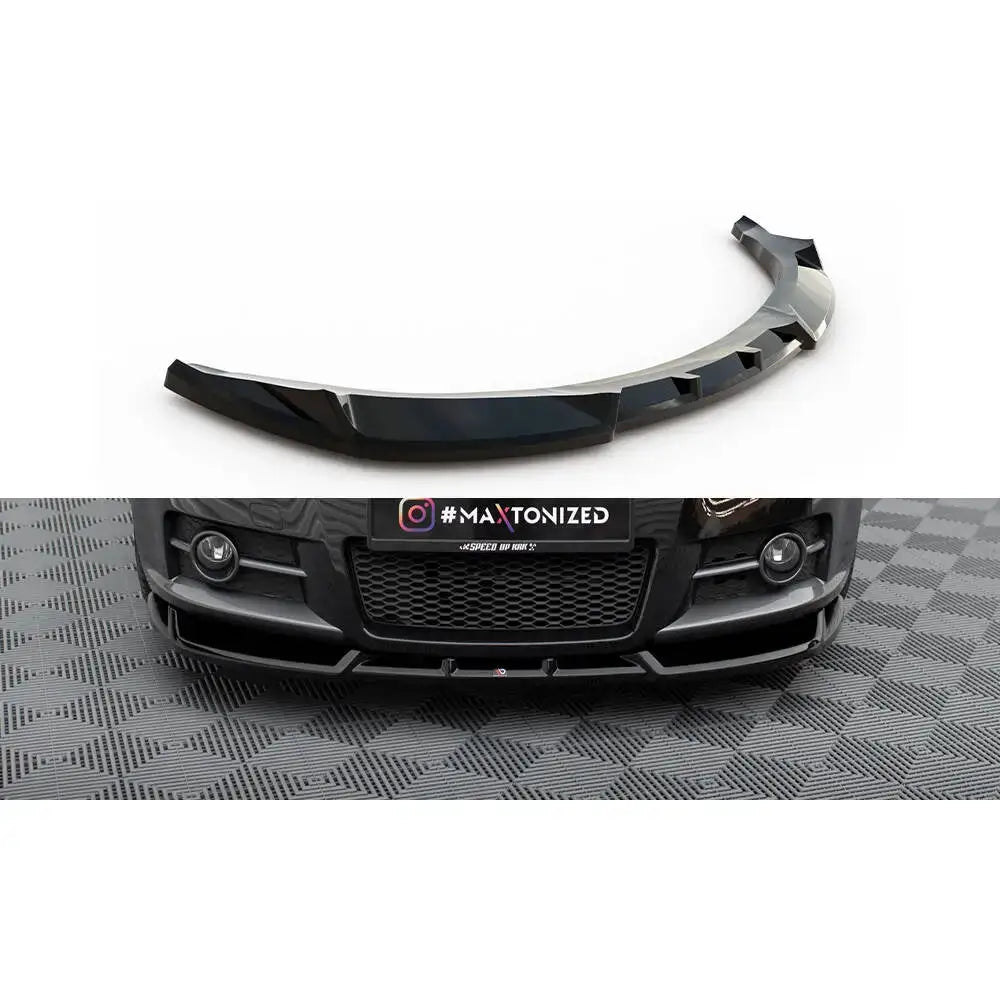 Frontspoiler til Suzuki Swift Sport Mk4 i sort, blank plast montert foran på bilen i garasje.