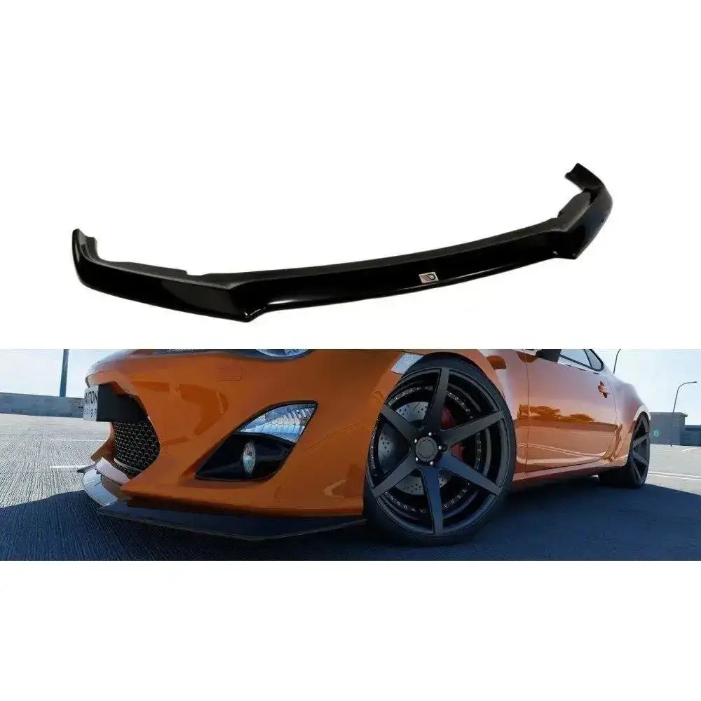 Frontspoiler til Toyota GT86 i sort plast, vist montert på oransje bil med synlig venstre forhjul.