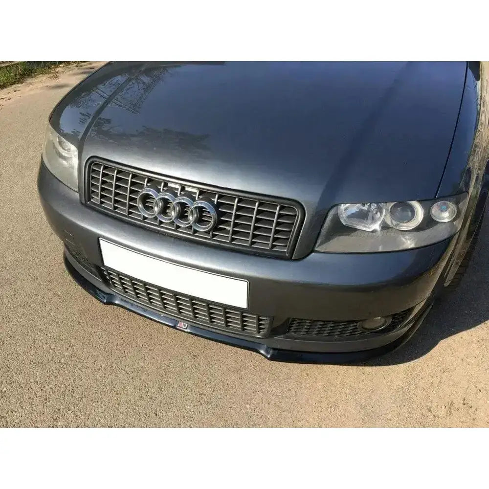 Front splitter på Audi A4 S-Line B6 V.1 med svart grill og blank sort leppe sett skrått forfra.