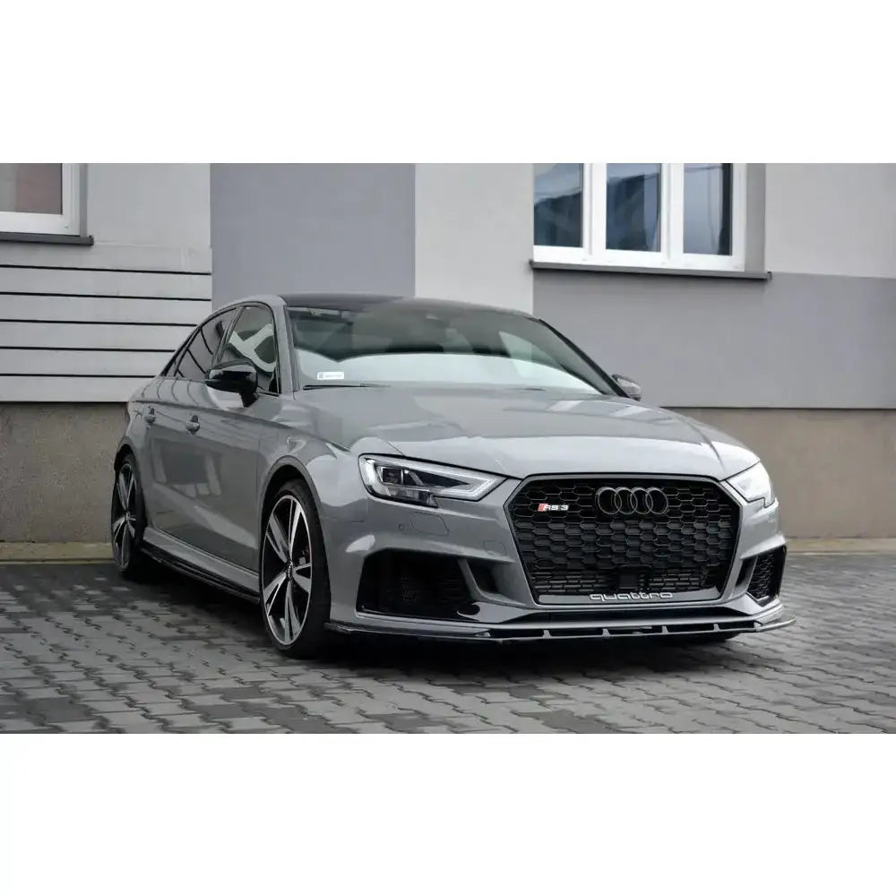 Frontspoiler på Audi RS3 8V FL sedan med sorte detaljer og store felger parkert på brostein.
