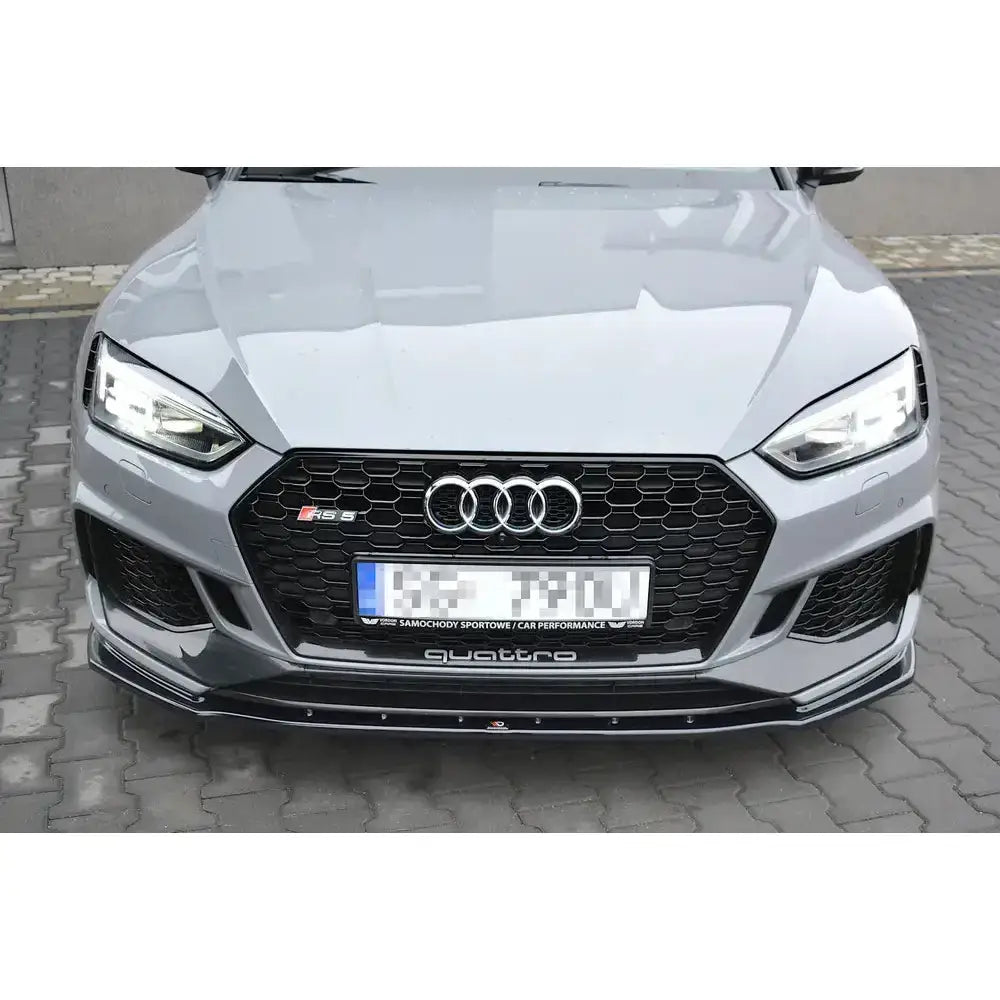 Front splitter på Audi RS5 F5 med sort bikubemønstret grill og quattro-logo nederst.
