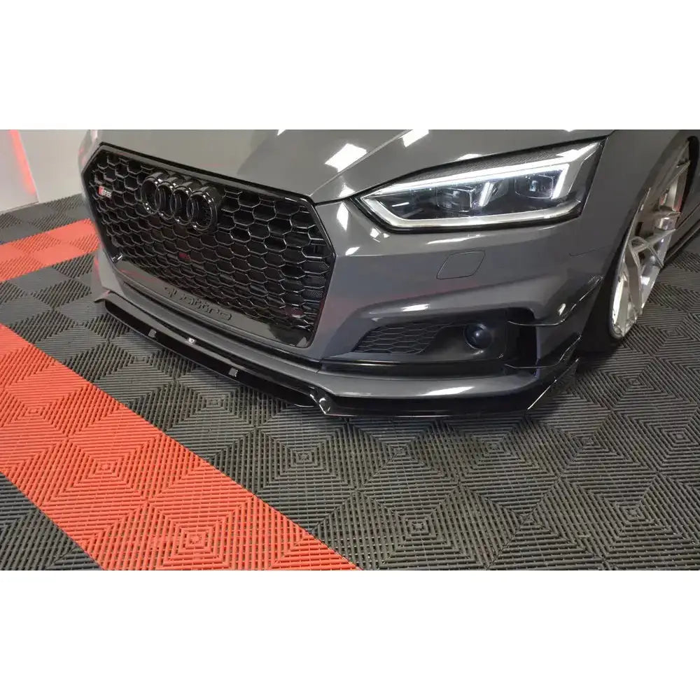 Front lip Audi S5 F5 V.1 montert på grå bil med sort grill, sett fra skrå vinkel på mønstret gulv.