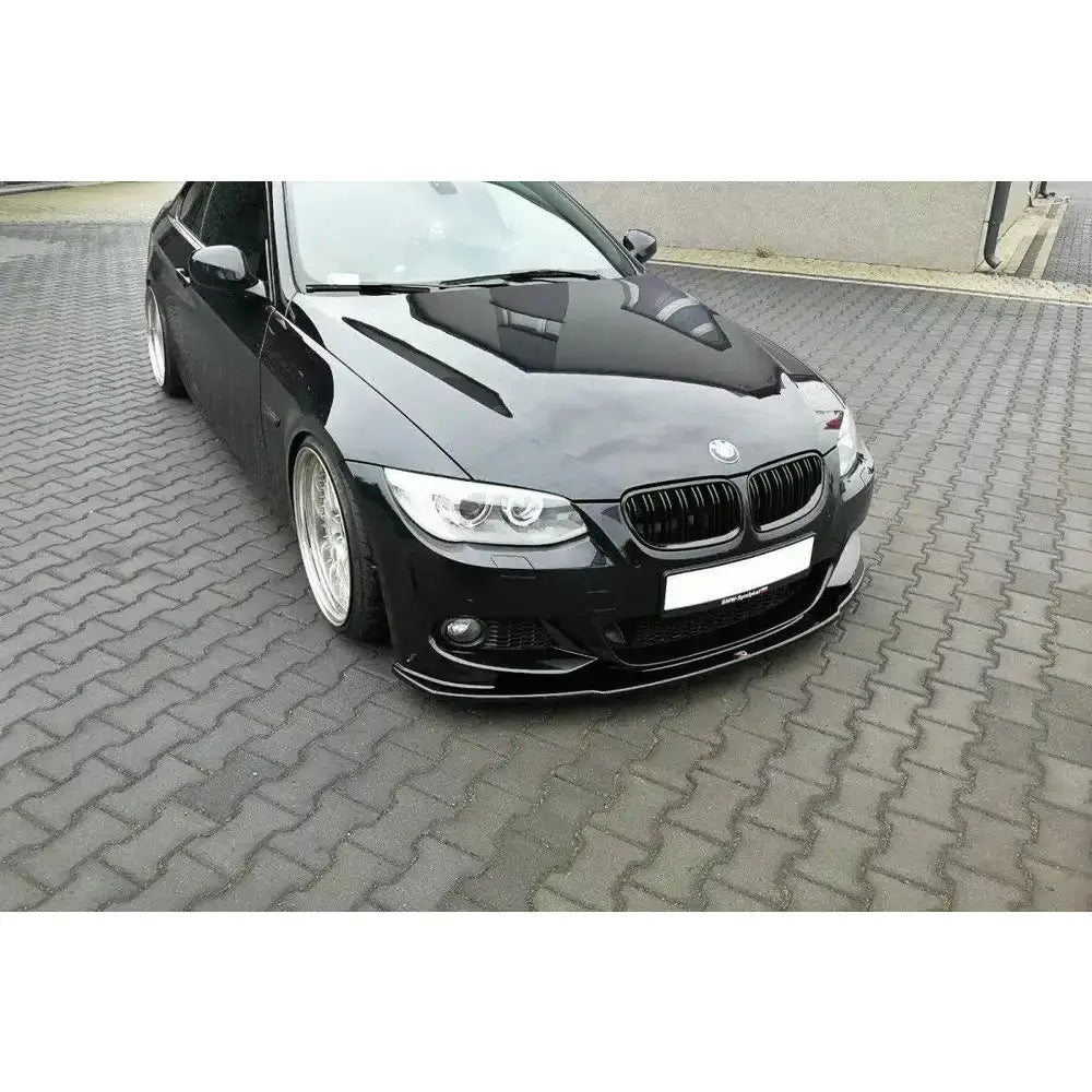 Frontspoiler BMW 3 E92 M-Pack Facelift V.1 på sort bil med sølvfelger, sett skrått forfra.