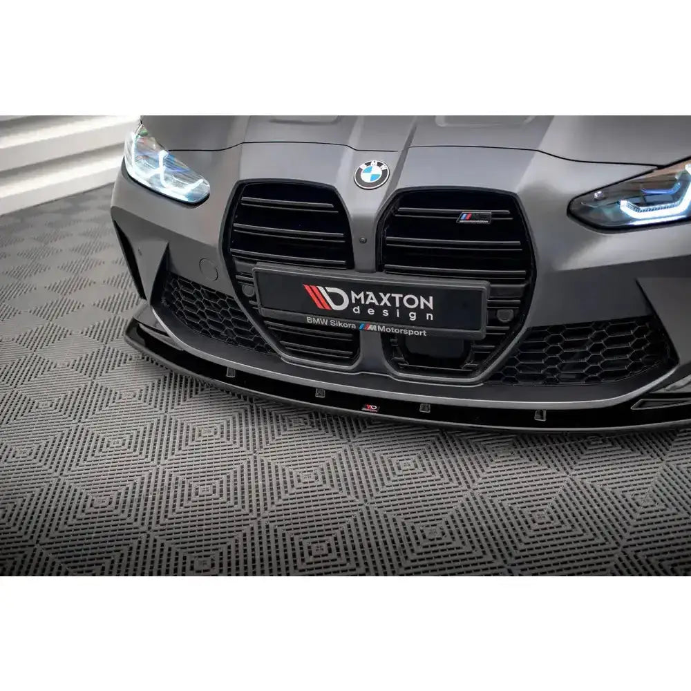 Front splitter på BMW M4 G82 V.1 montert på matt grå bil med sort grill, sett rett forfra.