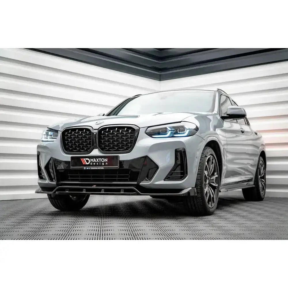 Frontleppe BMW X4 M-Pack G02 Facelift med svarte detaljer og LED-lys, sett fra skrå forside innendørs.