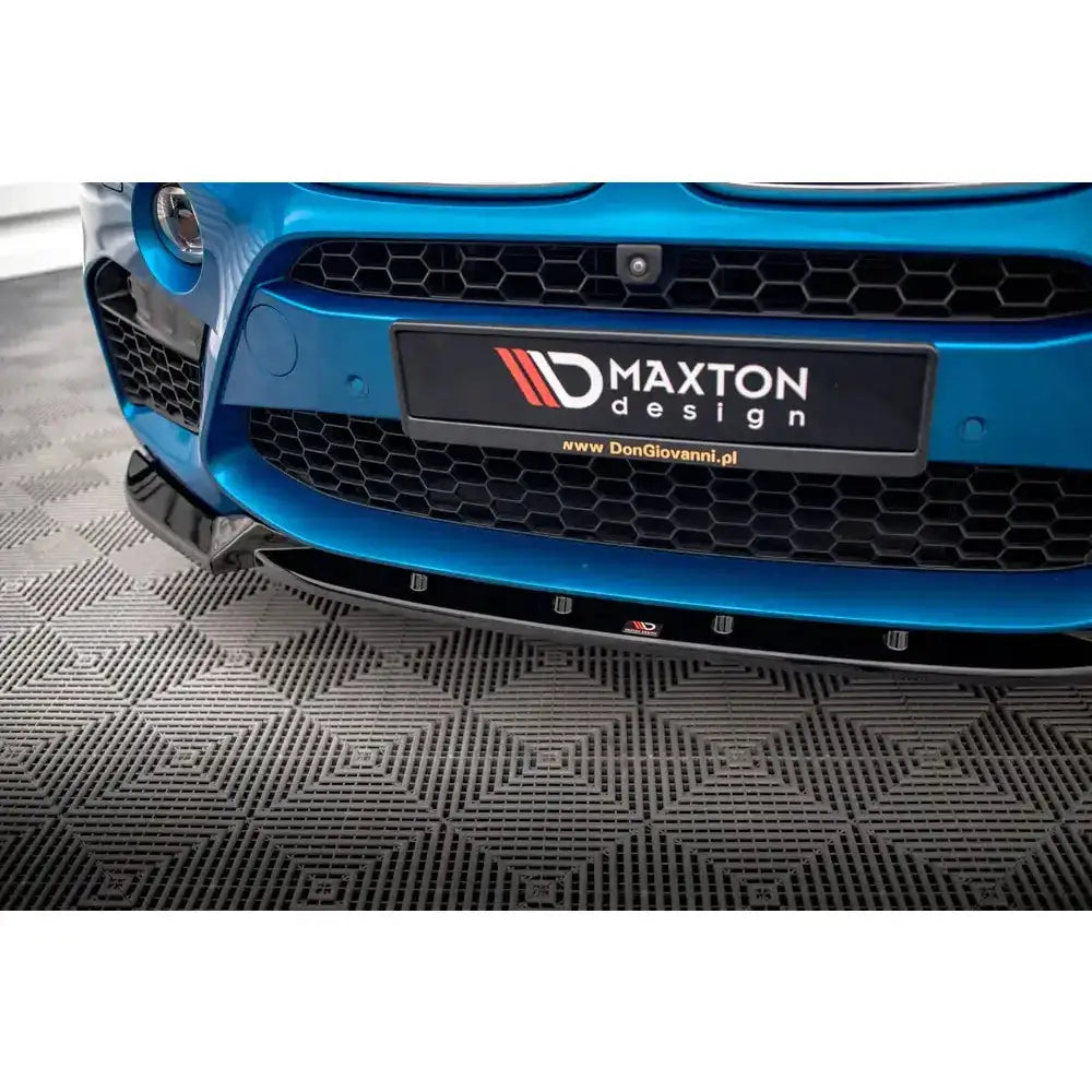 Frontspoiler BMW X5 M F15 V.1 i svart blank plast, nærbilde rett forfra med bikubegrill og Maxton design-skilt.