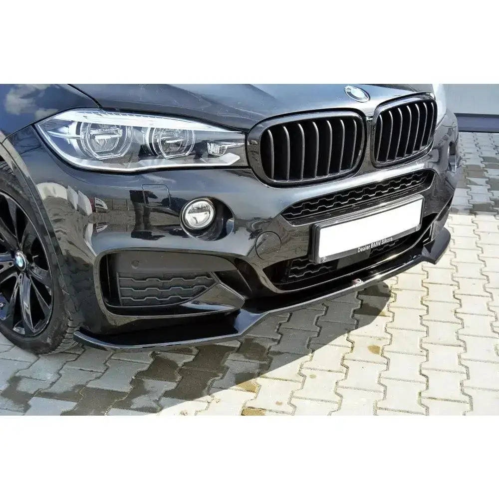 Spoiler til BMW X6 F16 Mpack V.1, nærbilde av svart frontspoiler, grill og frontlykt fra venstre side.