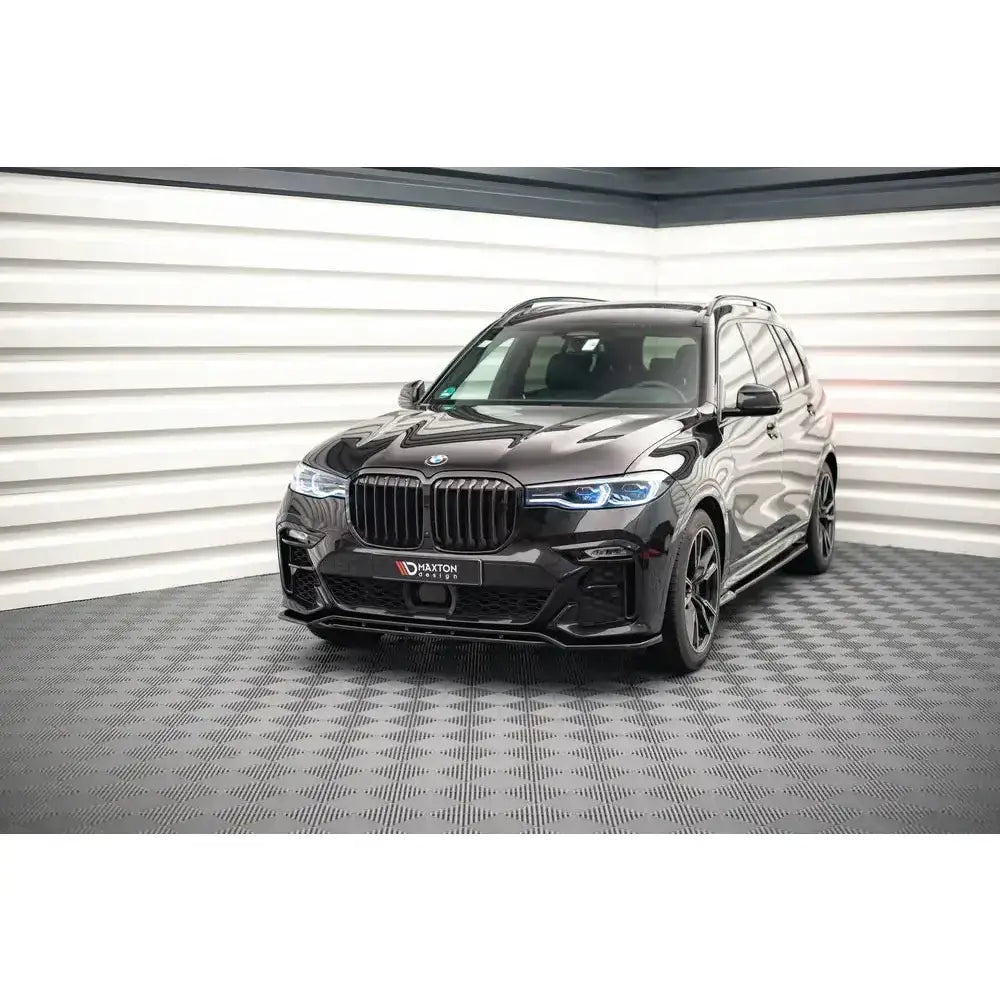 Frontleppe BMW X7 M G07 V.1 viser sort SUV forfra med LED-lykter og sportsfelger i lyst showroom.