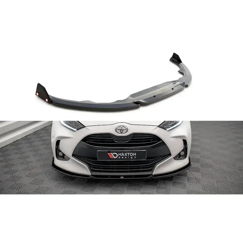 Frontspoiler Toyota Yaris Mk4 V.1 med flaps, sort plast, montert på hvit bil sett forfra.