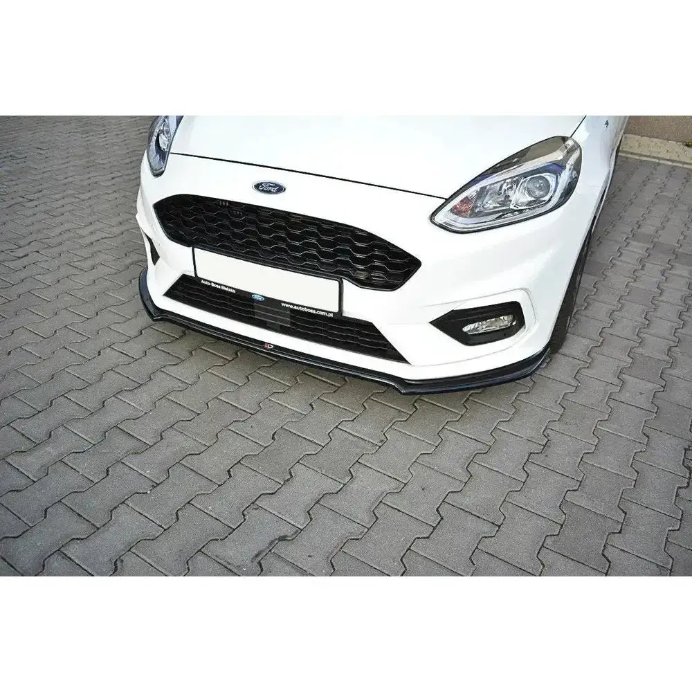Frontleppe på Ford Fiesta Mk8 med sort splitter og grill, bil parkert på grå belegningsstein.