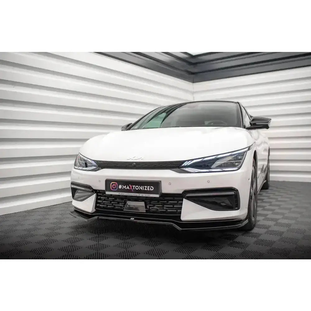 Front splitter på Kia EV6 GT-Line Mk1 med svarte detaljer og skarpe LED-frontlykter, sett skrått forfra.
