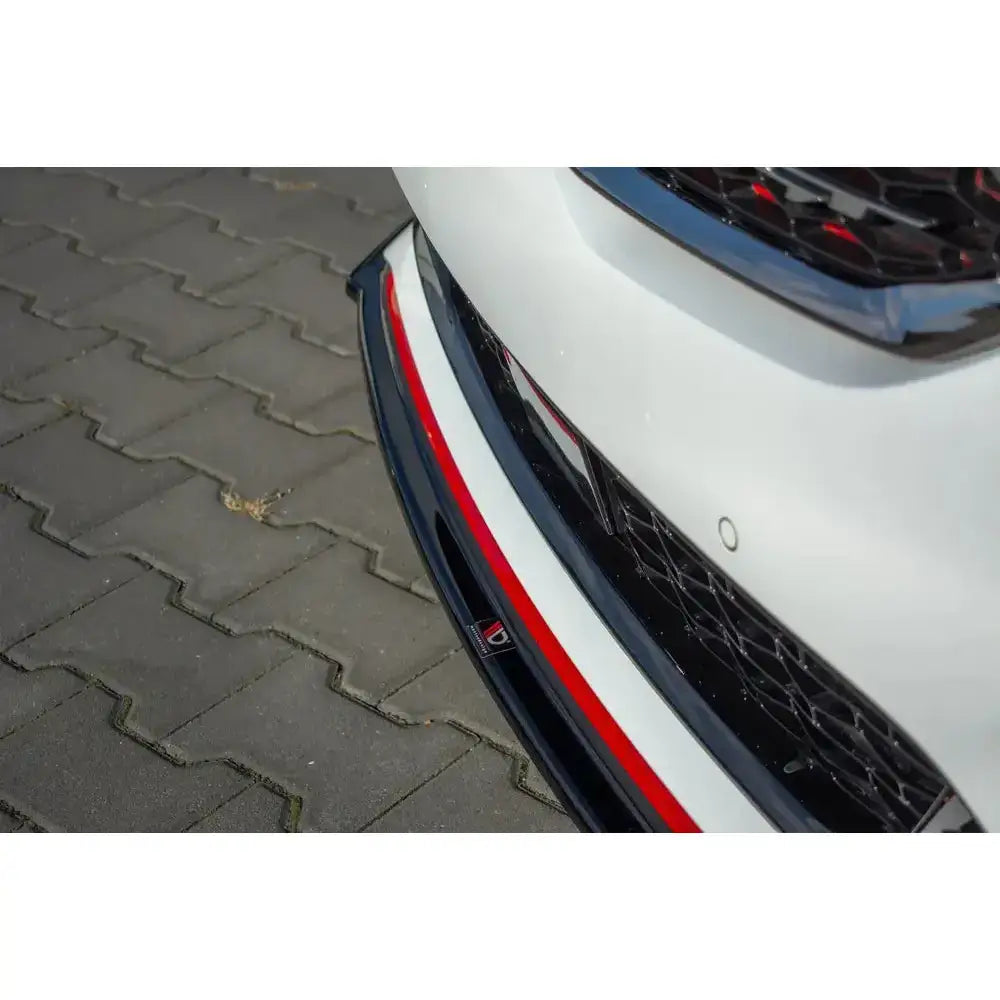 Frontspoiler Kia Proceed GT Mk 3 V.1 i svart og rødt på hvit bil, nærbilde mot asfalt og steinheller.