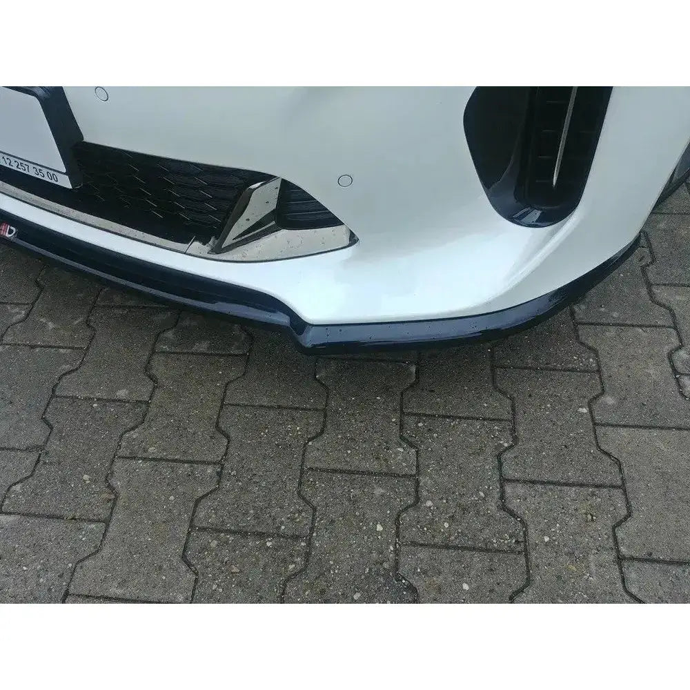 Front splitter på Kia Stinger GT V.1, svart plast montert under hvit frontfanger, skrå utendørs vinkel.