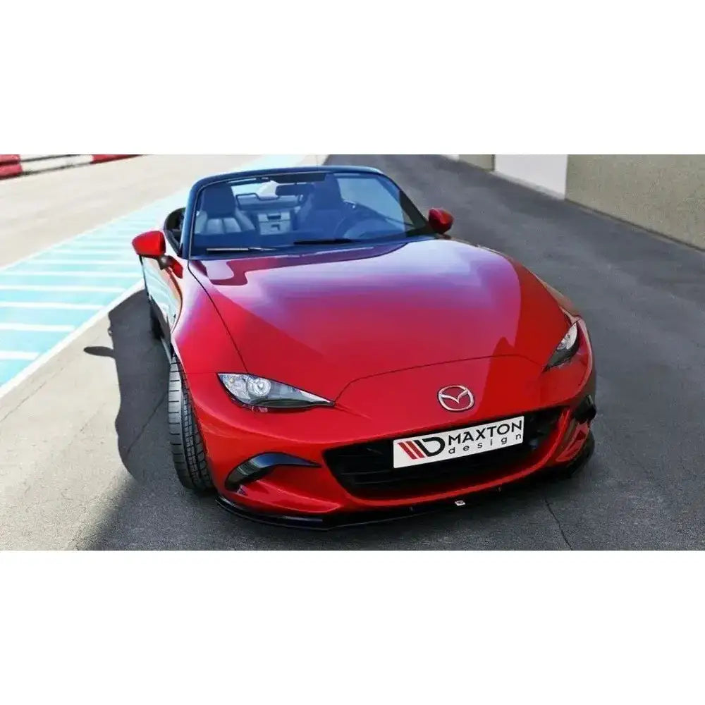 Frontleppe på Mazda Mx-5 IV V.1, rød sportsbil med svart spoiler og åpent tak, sett forfra.