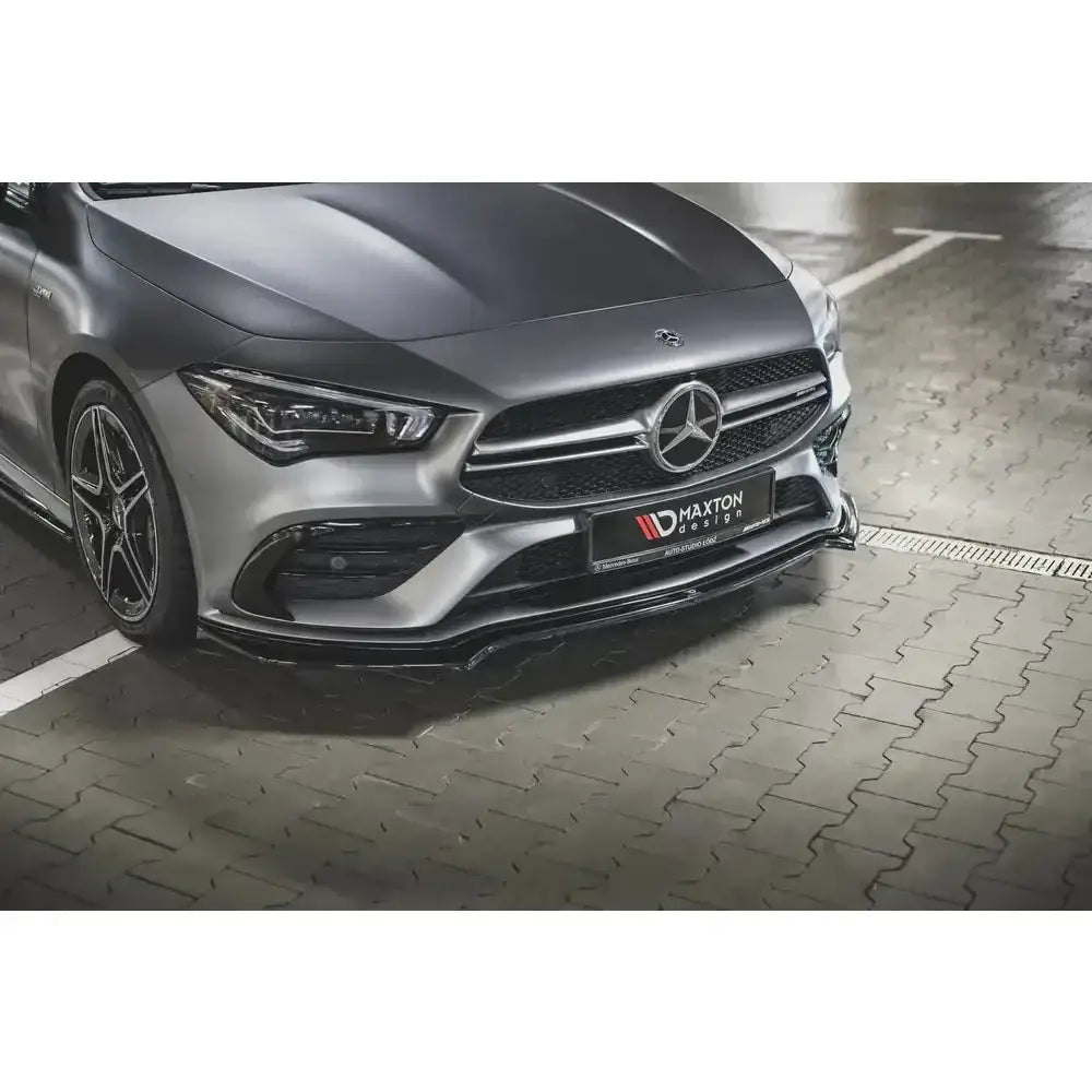Spoiler på Mercedes CLA 35 V.1 Aero C118 i sort blank finish, sett forfra på lys grå asfalt.