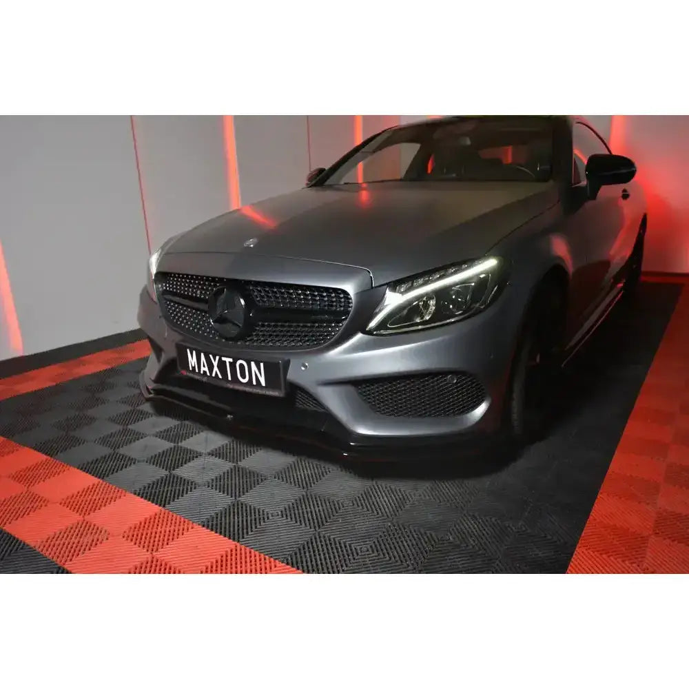 Frontspoiler på Mercedes C-Klasse W205 Coupe med sorte detaljer og LED-lys, parkert på sjakkmønstret gulv.