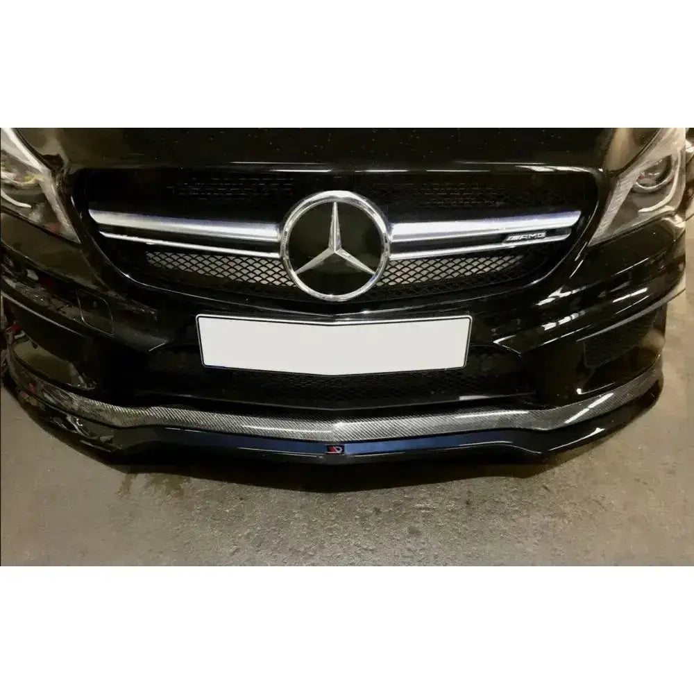 Spoiler på Mercedes CLA 45 AMG C117 med synlig grill, AMG-emblem og karbonfiber-look frontsplitter.
