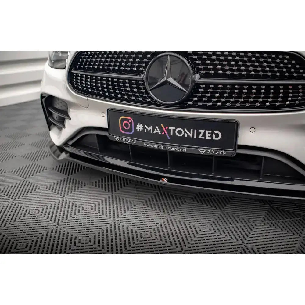 Front splitter til Mercedes E-Klasse AMG-Line W213 Facelift, sort blank plast montert på hvit bil.