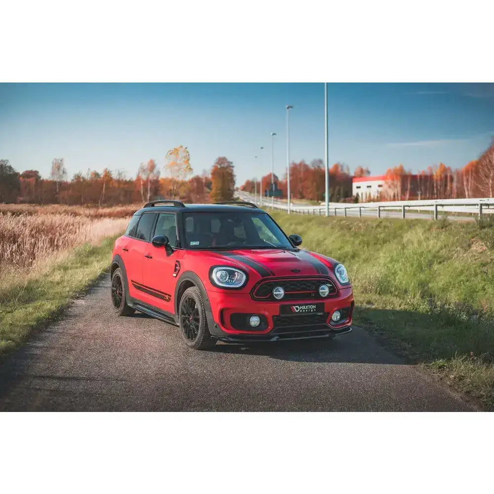Frontleppe på rød Mini Countryman Mk2 F60 JCW med svarte detaljer og ekstralys, sett skrått forfra.