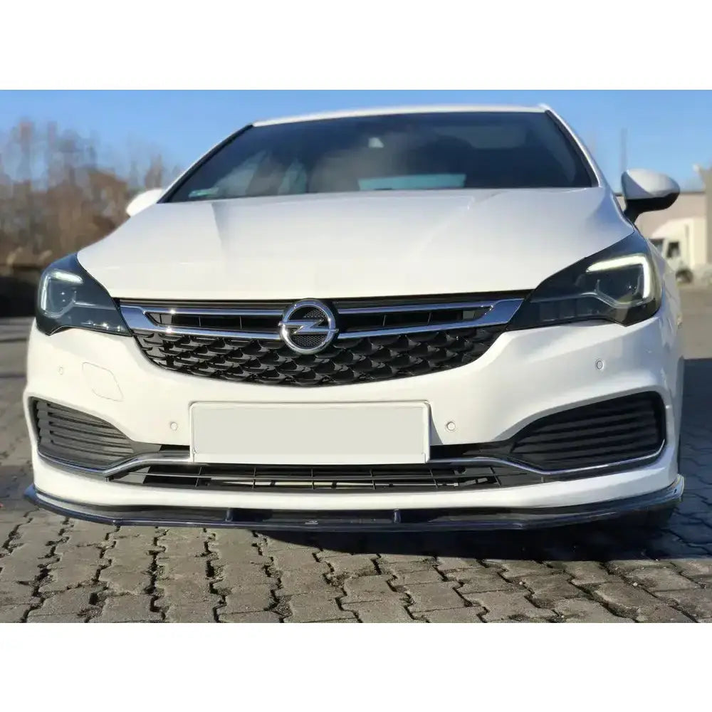 Spoiler på Opel Astra K Opc-Line sett forfra med kromgrill og sorte detaljer, parkert på brostein.