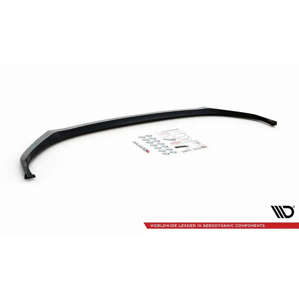 Frontspoiler Skoda Enyaq iV V.1 sett ovenfra med monteringsutstyr og klistremerker på hvit bakgrunn.