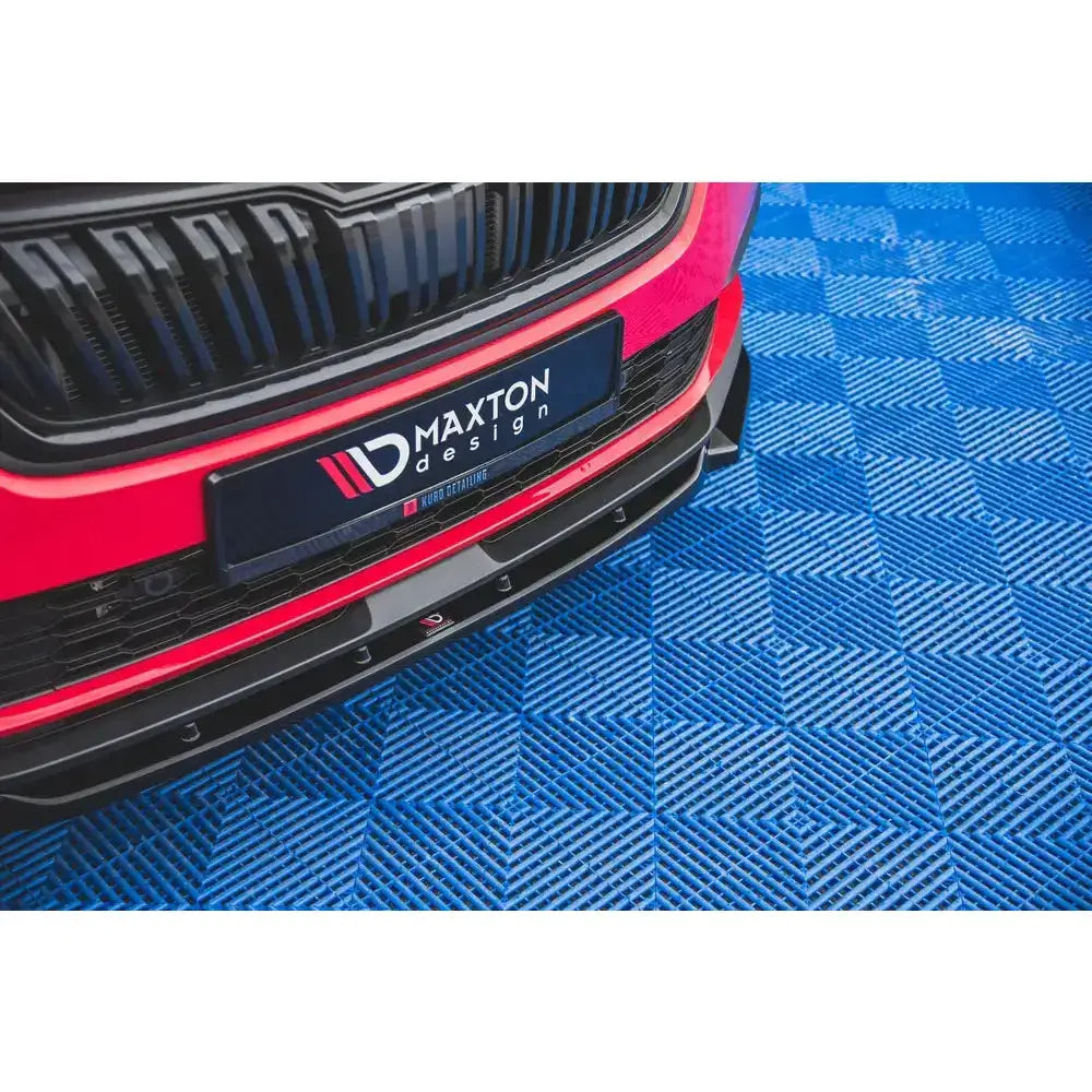 Spoiler på rød Skoda Kamiq V.1 med svart grill og frontsplitter, sett ovenfra på blått rutegulv.