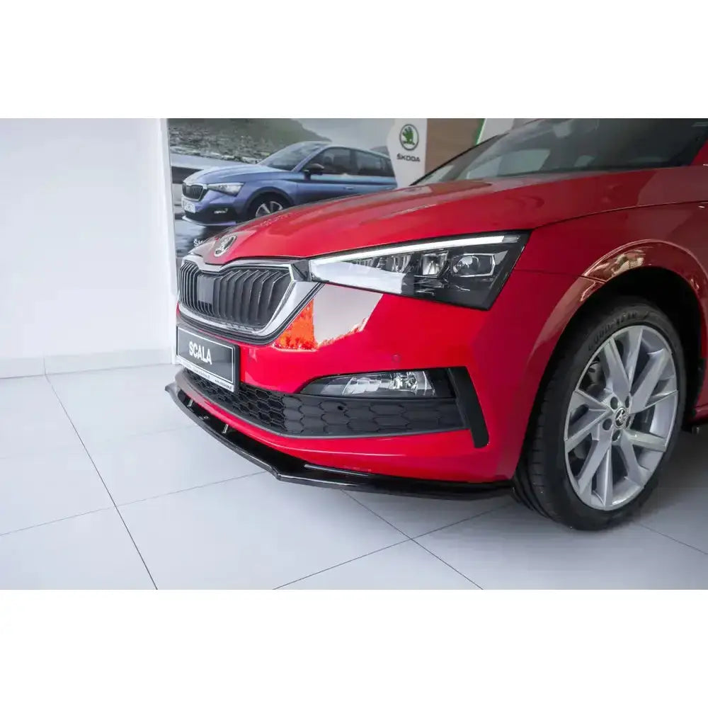 Front splitter på rød Skoda Scala V.1 med sort spoiler og LED frontlykter, sett fra venstre hjørne.