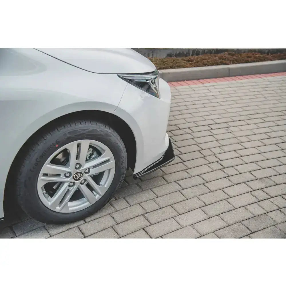 Front lip på Toyota Corolla XII Touring Sports med sølvfelg og sort detalj på hvit støtfanger.